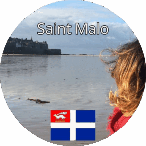 Femme de dos regardant la mer face aux remparts de Saint-Malo avec le drapeau de la ville en bas de l’image